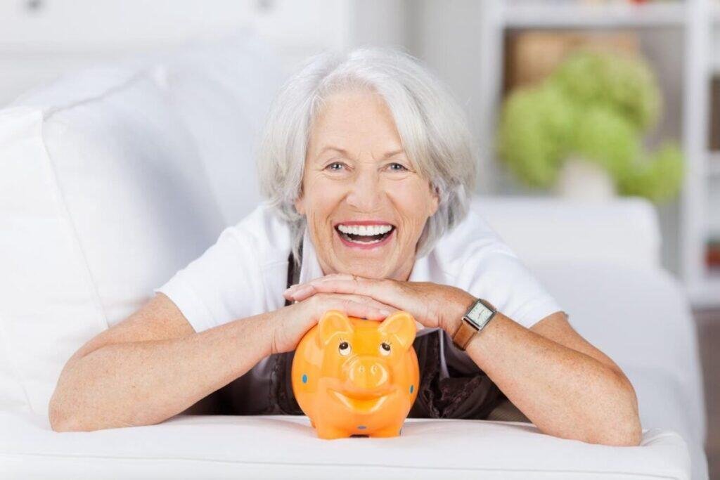 Happy senior woman with Australian age pension savings piggy bank.