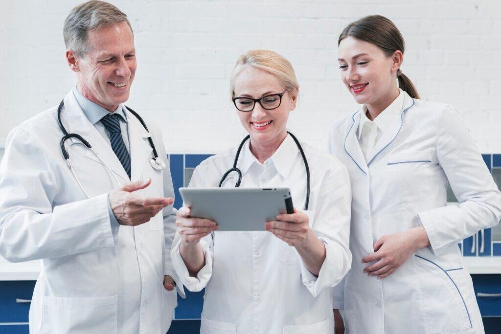 Three Australian doctors reviewing a tablet.