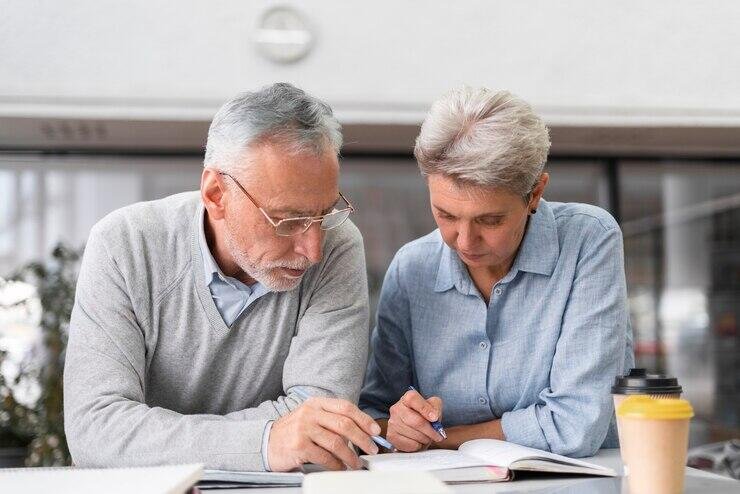 Senior Adelaide business owners reviewing documents together.
