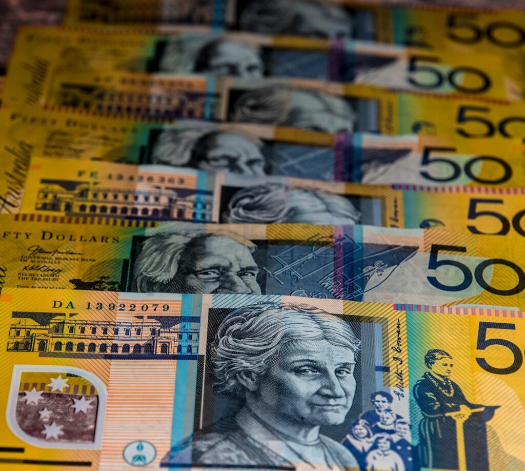 Close-up view of Australian $50 bills arranged in a pattern. Vibrant colors and detailed imagery highlight currency features.