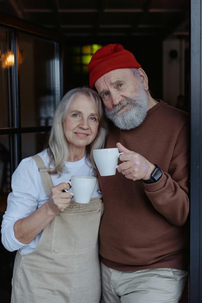 Warm and loving elderly couple sharing a relaxed coffee moment indoors.